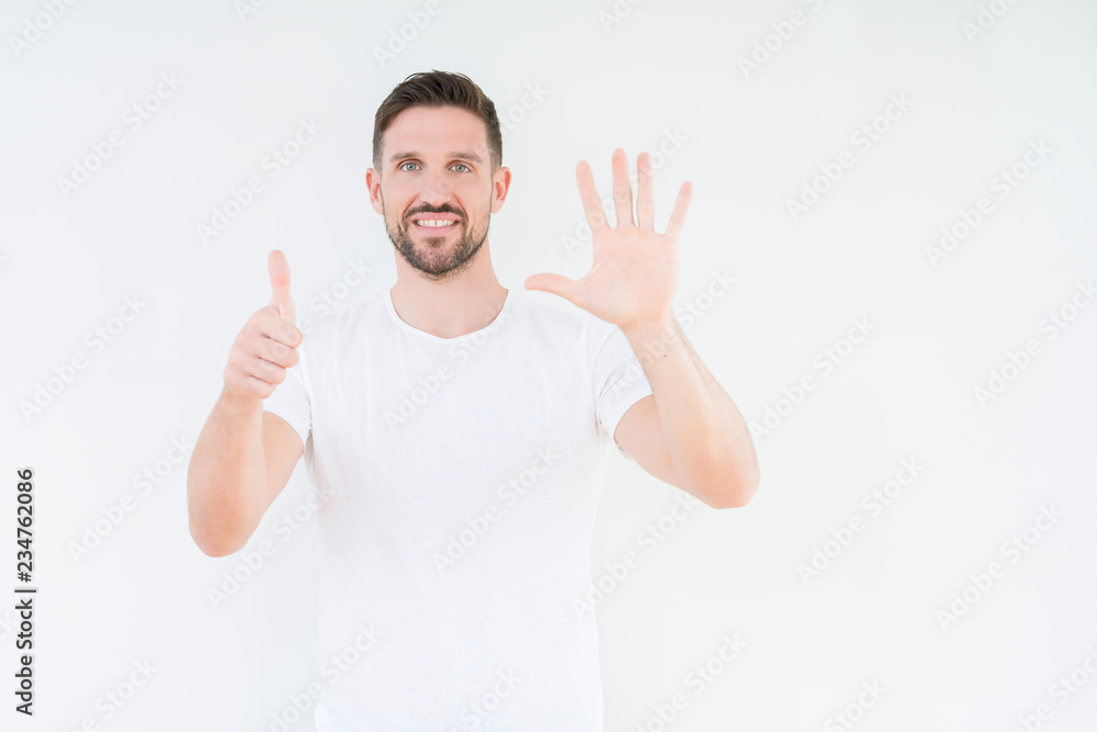 Young handsome man wearing casual white t-shirt over isolated background showing and pointing up with fingers number six while smiling confident and happy. Young handsome man wearing casual white t-shirt over isolated background showing and pointing up with fingers number six while smiling confident and happy.