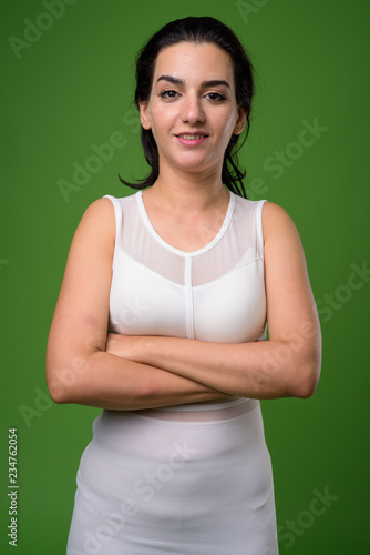 Portrait of beautiful Iranian woman against green background