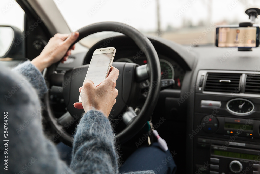 The driver in the car holds in hand the phone