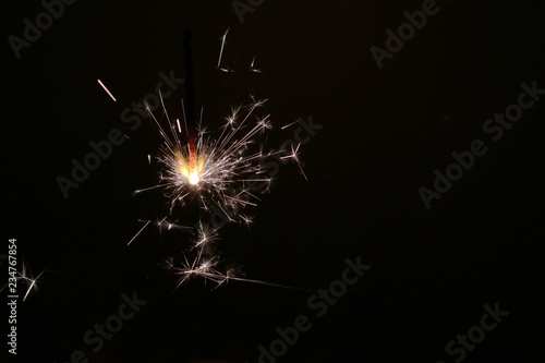 Sparkler on a dark background as a symbol of the New year holiday.