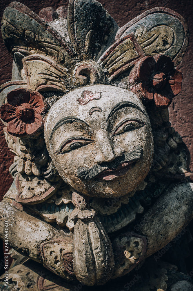 Closeup portrait of Hindu Buddhist traditional stone sculpture. Bali, Indonesia