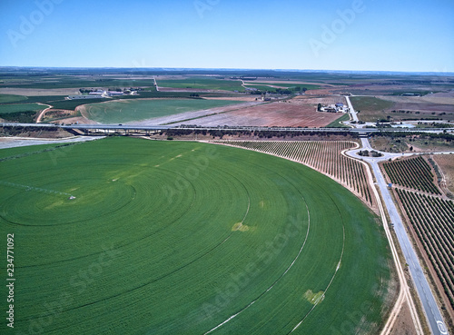 Aerial view of crop field with circular pivot irrigation sprinkler.