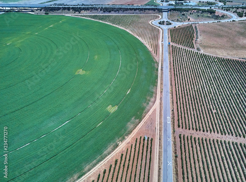 Aerial view of crop field with circular pivot irrigation sprinkler.