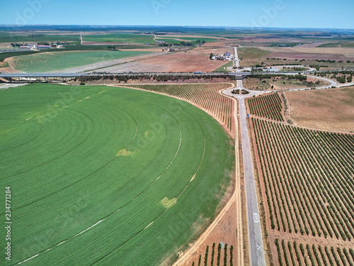 Aerial view of crop field with circular pivot irrigation sprinkler.