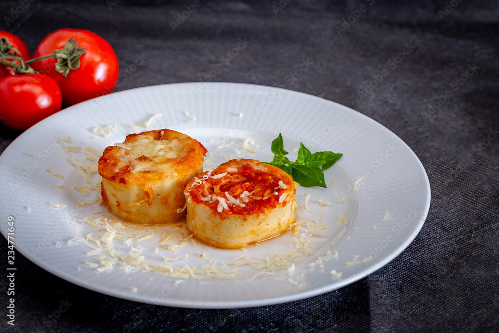 Italian rondelli with pomodoro sauce and cheese on rustic background.