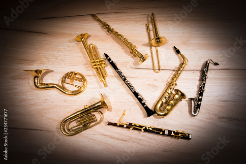 A number of toy wind instruments  lying on a wooden board, dark vignette