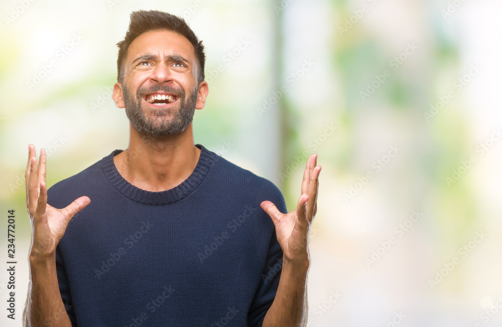 Adult hispanic man over isolated background crazy and mad shouting and yelling with aggressive expression and arms raised. Frustration concept. Adult hispanic man over isolated background crazy and mad shouting and yelling with aggressive expression and arms raised. Frustration concept.