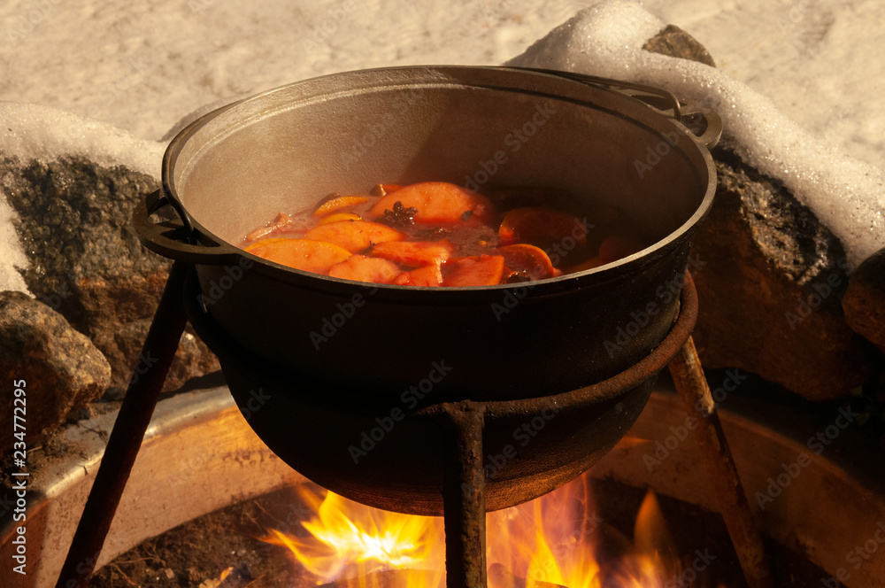 Cauldron with the mulled wine cooked over the fire Cauldron with the mulled wine cooked over the fire