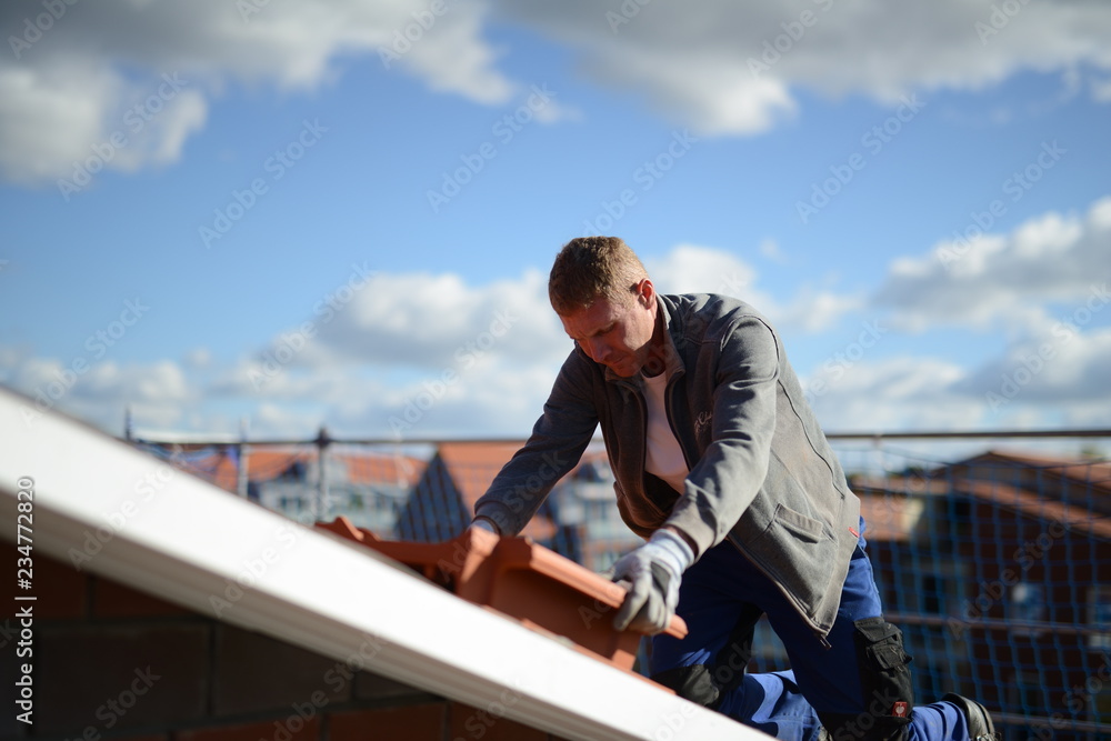 Handwerkskammer - Ausbildung zum Dachdecker: Arbeitshandschuhe anziehen beim Dachpfannen eindecken