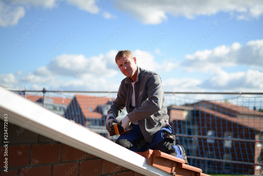 Heimwerker oben unter freiem Himmel beim Freizeit nutzen: Dachdecker Facharbeiter Erfahrung auf dem Bau, Dachziegel fest schrauben Heimwerker oben unter freiem Himmel beim Freizeit nutzen: Dachdecker Facharbeiter Erfahrung auf dem Bau, Dachziegel fest schrauben