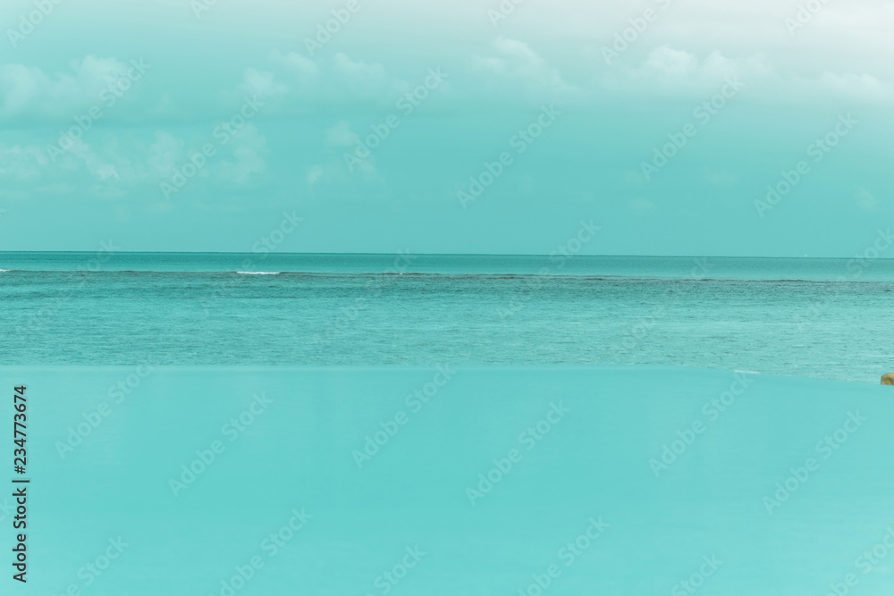 Türkis blause Wasseroberfläche von einem Infinity Pool und Ozean