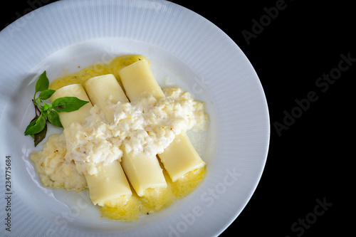 Italian caneloni with bechamel sauce and cheese on rustic background. photo