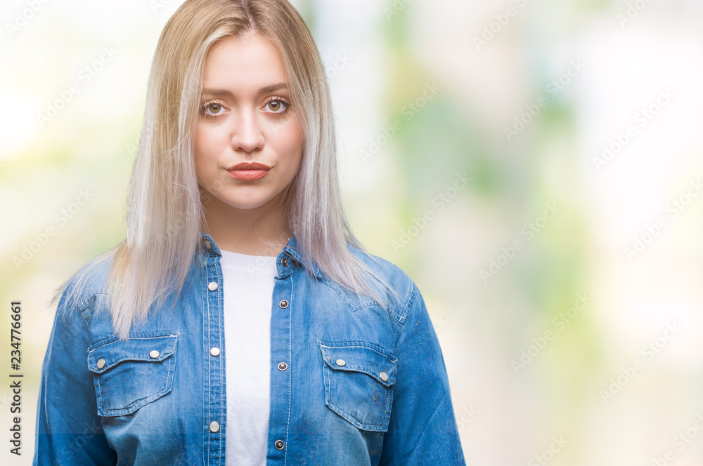 Young blonde woman over isolated background with serious expression on face. Simple and natural looking at the camera. Young blonde woman over isolated background with serious expression on face. Simple and natural looking at the camera.