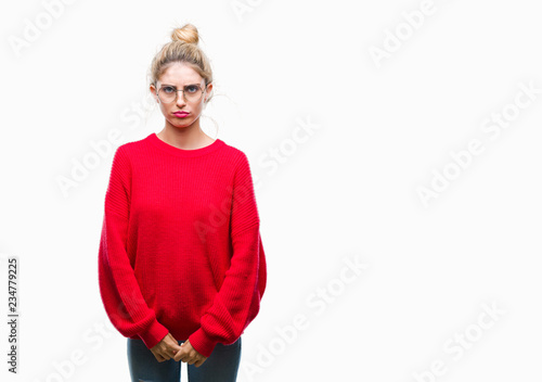Young beautiful blonde woman wearing red sweater and glasses over isolated background depressed and worry for distress, crying angry and afraid. Sad expression. © Krakenimages.com