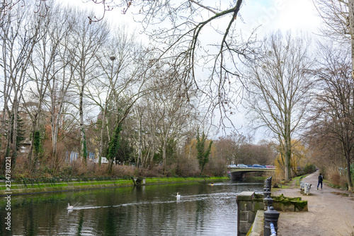 View of riverside, river bank, waterside and walking street beside Landwehr canal in Kreuzberg surrounded by cloudy atmosphere of city public park in winter season in Berlin, Germany.  photo