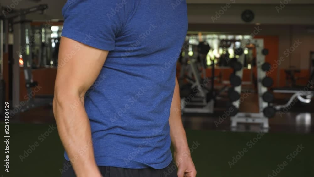 Detail of athletic young man's torso and arm doing bicep curls. Detail of athletic young man's torso and arm doing bicep curls.