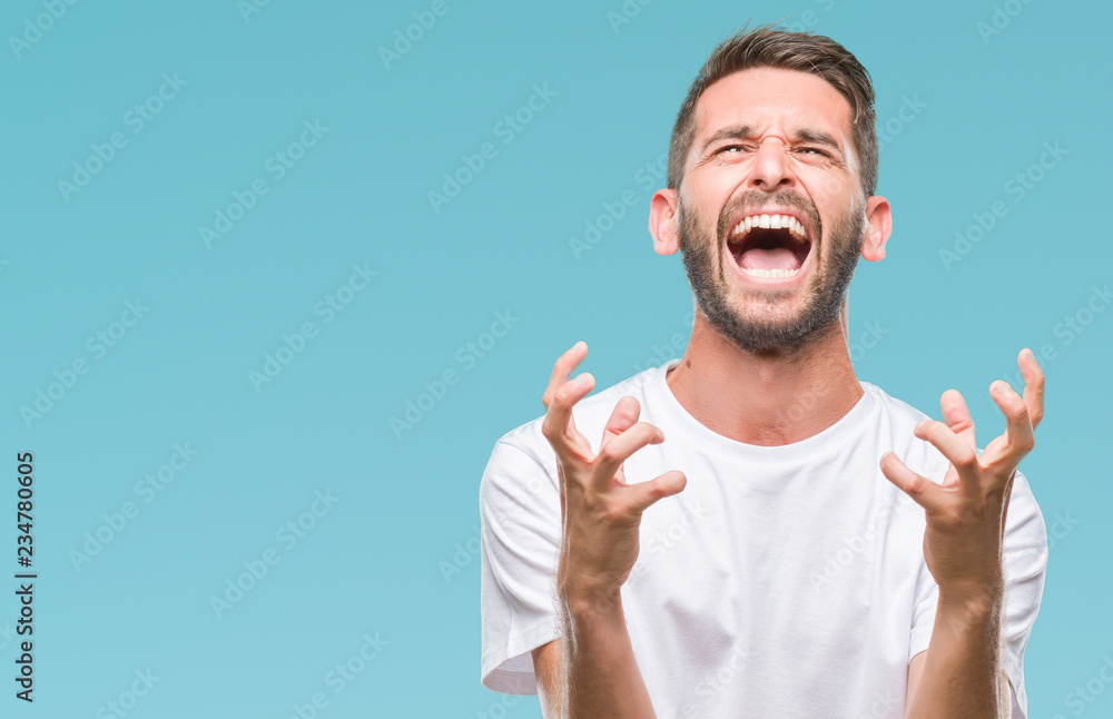 Young handsome man over isolated background crazy and mad shouting and yelling with aggressive expression and arms raised. Frustration concept. Young handsome man over isolated background crazy and mad shouting and yelling with aggressive expression and arms raised. Frustration concept.