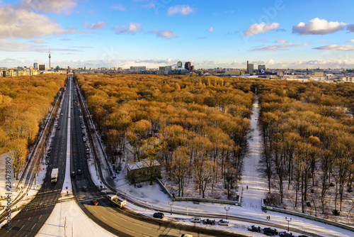 Aerial panoramic view of cityscape of Berlin skyline and scenery of trees without leaves in winter season at Tiergarten park from above at Victory Column with background of dusk sunset sky in Berlin.