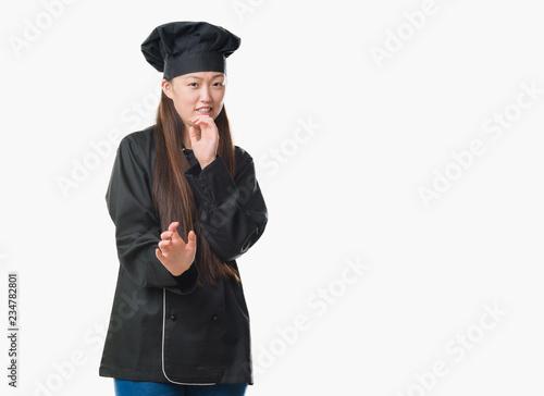 Young Chinese woman over isolated background wearing chef uniform disgusted expression, displeased and fearful doing disgust face because aversion reaction. With hands raised. Annoying concept.