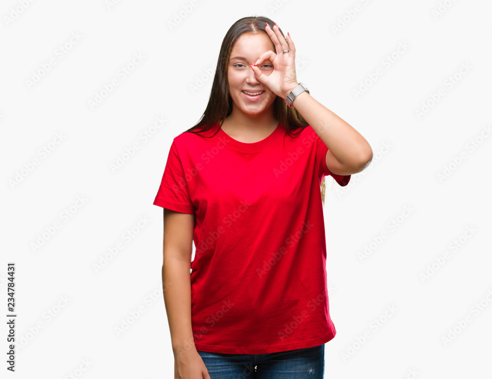 Young beautiful caucasian woman over isolated background doing ok gesture with hand smiling, eye looking through fingers with happy face. Young beautiful caucasian woman over isolated background doing ok gesture with hand smiling, eye looking through fingers with happy face.