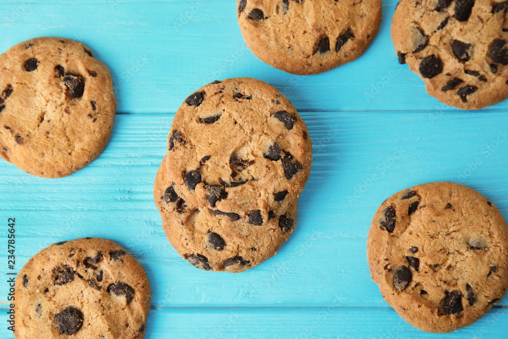 Tasty chocolate chip cookies on wooden background, top view