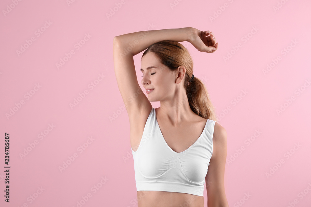 Young woman showing armpit on color background. Using deodorant Young woman showing armpit on color background. Using deodorant