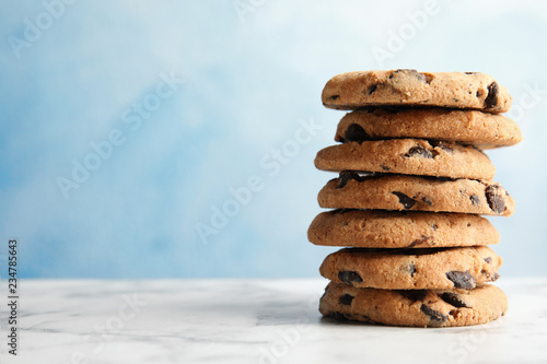 Stack of tasty chocolate chip cookies on table. Space for text