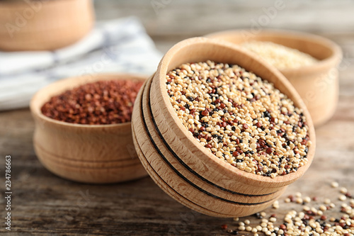 Bowl with mixed quinoa seeds on wooden table