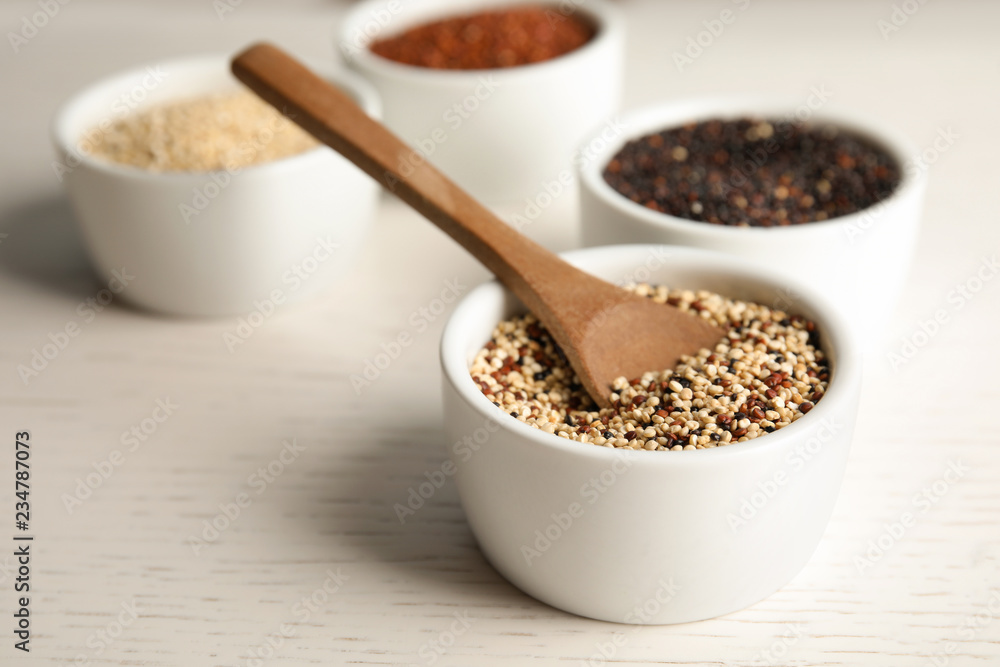 Spoon and bowl with mixed quinoa seeds on table. Space for text Spoon and bowl with mixed quinoa seeds on table. Space for text