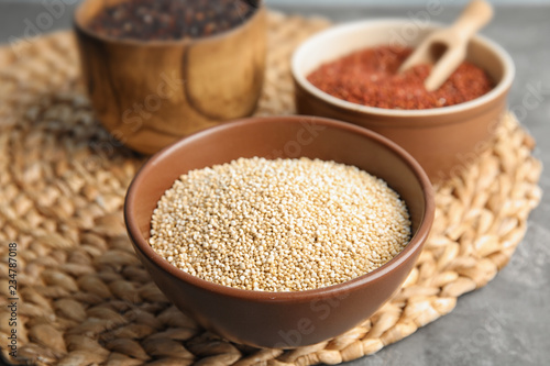 Composition with white quinoa in bowl on wicker mat