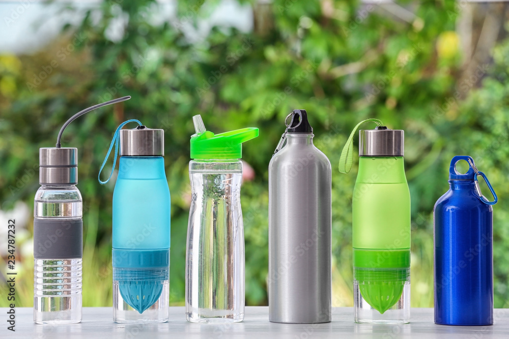 Obraz premium Sports water bottles on table against blurred background