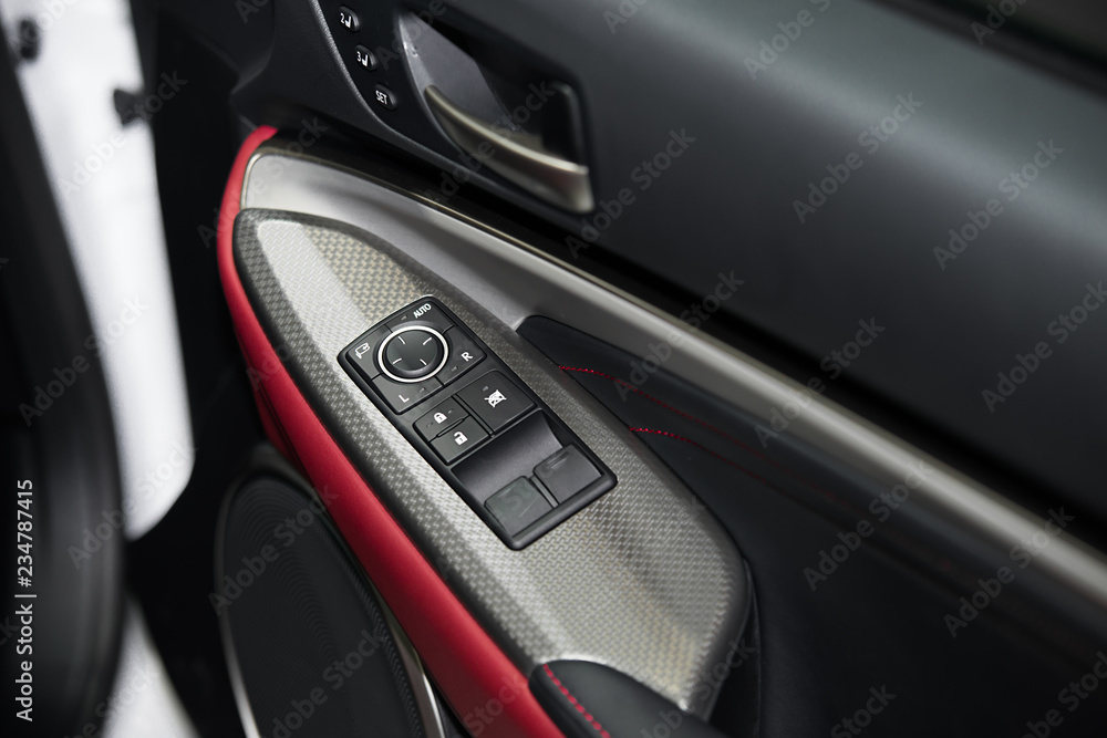 Detail on buttons controlling the windows in red car.