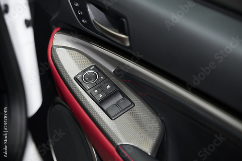 Detail on buttons controlling the windows in red car. © ake1150