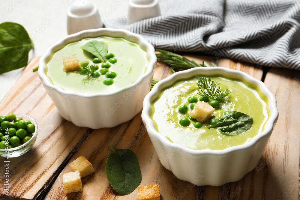 Fresh vegetable detox soup made of green peas and spinach with croutons served on board Fresh vegetable detox soup made of green peas and spinach with croutons served on board
