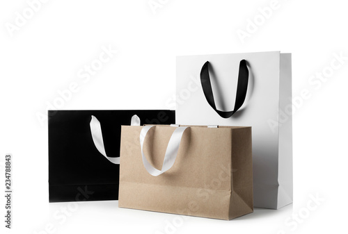 Photos Paper shopping bags with ribbon handles on white background