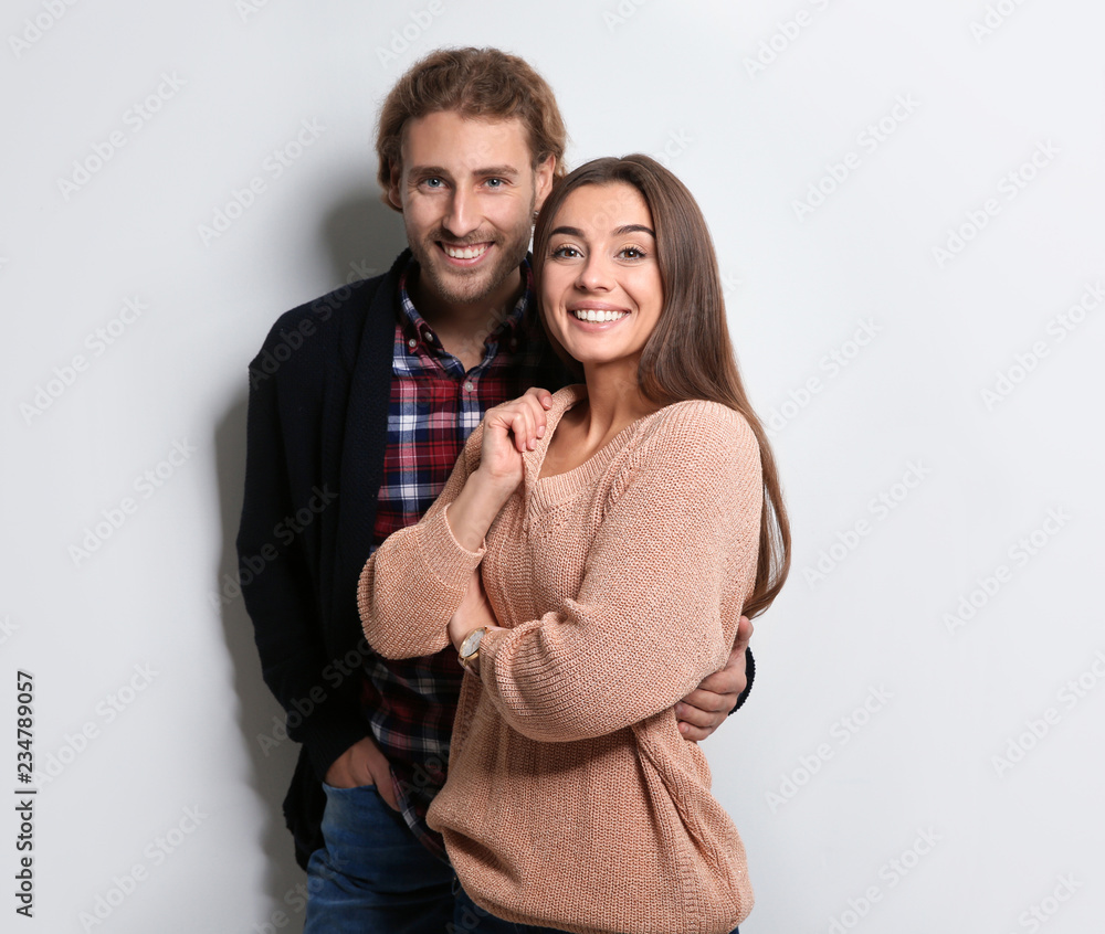 Young woman in warm sweater and man wearing knitted cardigan on white background Young woman in warm sweater and man wearing knitted cardigan on white background