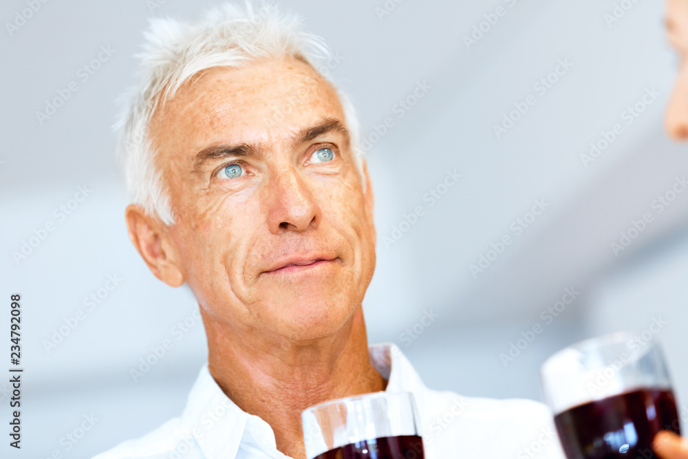 Senior man with holding a glass of wine indoors Senior man with holding a glass of wine indoors