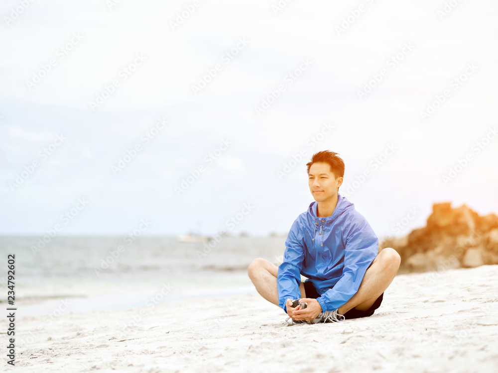 Young man doing exercise at the beach