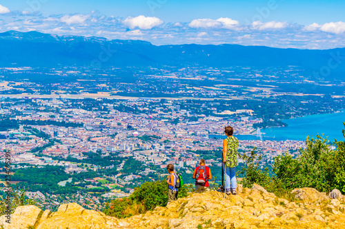 Three adults are overlooking Geneva from Mont Saleve, Switzerland