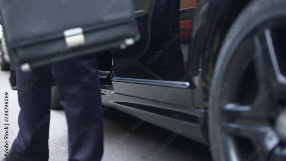 Successful businessman getting out of premium class car, arrival to workplace Successful businessman getting out of premium class car, arrival to workplace