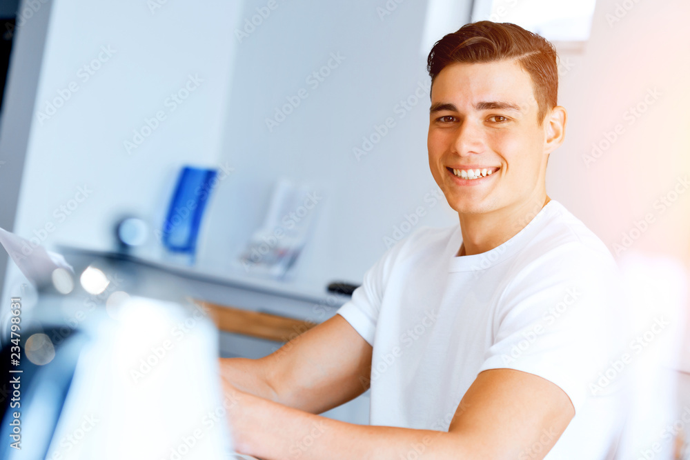 Young man with papers in their living room Young man with papers in their living room