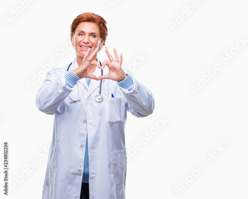 Senior caucasian doctor woman wearing medical uniform over isolated background smiling in love showing heart symbol and shape with hands. Romantic concept.