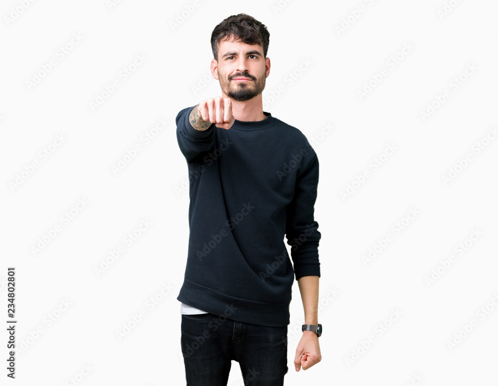 Young handsome man over isolated background Punching fist to fight, aggressive and angry attack, threat and violence Young handsome man over isolated background Punching fist to fight, aggressive and angry attack, threat and violence