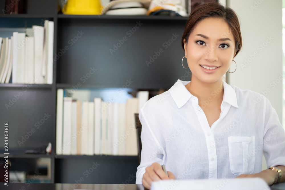Asian business women using notebook and smiling happy for working Asian business women using notebook and smiling happy for working