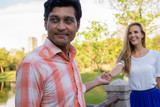 Close up of happy multi ethnic couple smiling with Indian man le
