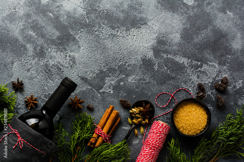 Fototapeta Naklejka Na Ścianę i Meble -  New Year food background. Ingredients for making Christmas mulled wine (bottle of red wine, orange, cane sugar and spices). Top view.