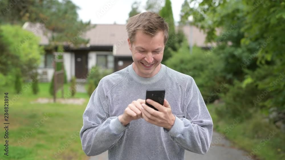Young Happy Handsome Man Using Phone At Home Outdoors Young Happy Handsome Man Using Phone At Home Outdoors
