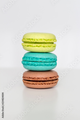 Fototapeta Naklejka Na Ścianę i Meble -  Turquoise, brown and green macarons on the white table. Close-up, front view, copy space