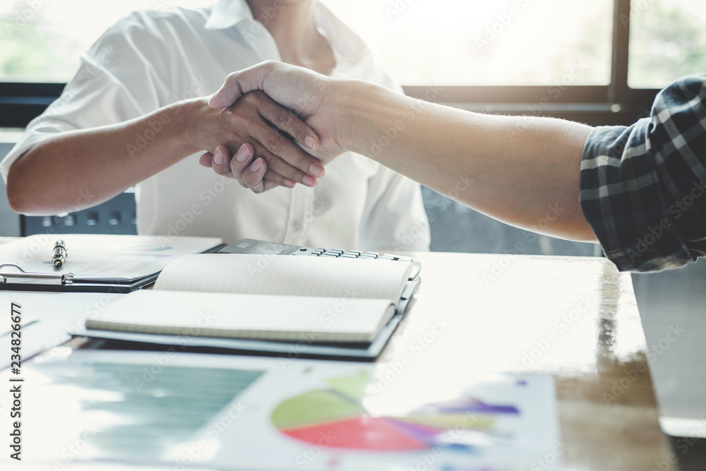 Business team two shaking hands after a meeting to sign agreement and become partner in the office, contract between their firms