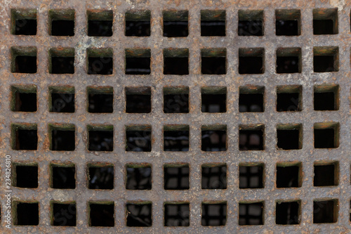 Old rusty iron street water sewer grate closeup top view